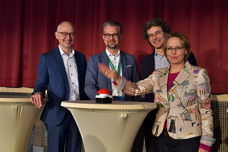 André Göbel, Ina-Maria Ulbrich und zwei weitere Personen beim Drücken des Buzzers